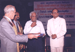 Thiru S. Ramakrishnan,I.A.S. holding an artefact (a dagger) in his hand. Dr. R. Kannan and H.E. Rob Lawrie look on.